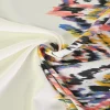 Viscose stretch crêpe – Kleurrijke ikat op gebroken wit randdesign