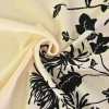 Viscose stretch crêpe – Zwarte bloem op champagne randdesign