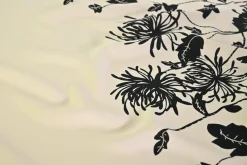 Viscose stretch crêpe – Zwarte bloem op champagne randdesign